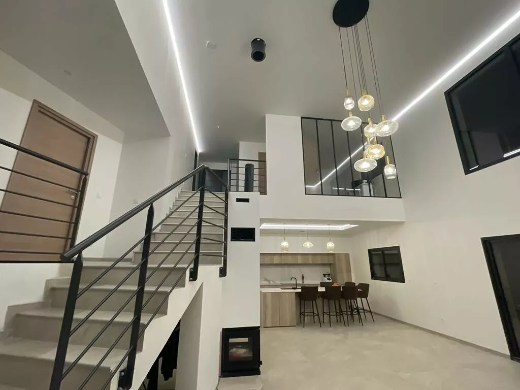 Mezzanine au garde-corps noir dominant le séjour – maison individuelle en Isère, AEA Architecte Constructeur