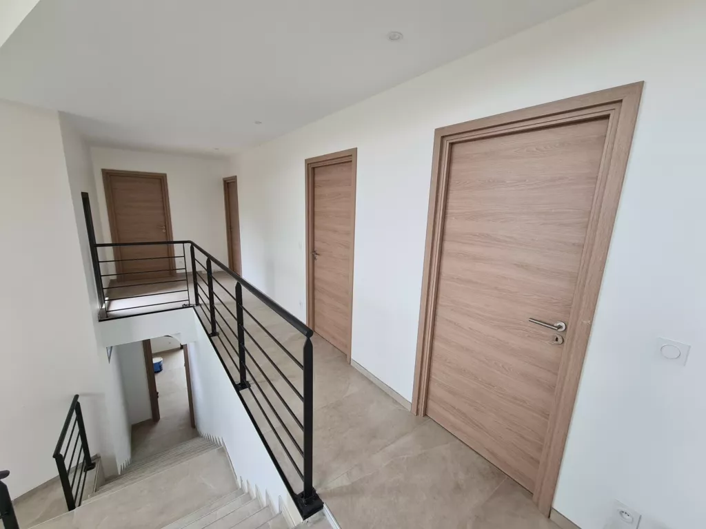 Palier de l’étage et portes en bois – maison individuelle en Isère, AEA Architecte Constructeur