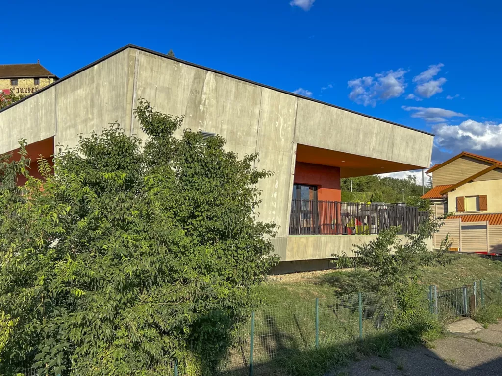 Pignon en béton brut et végétation – pôle enfance de Faramans (Isère), AEA Architecte Constructeur