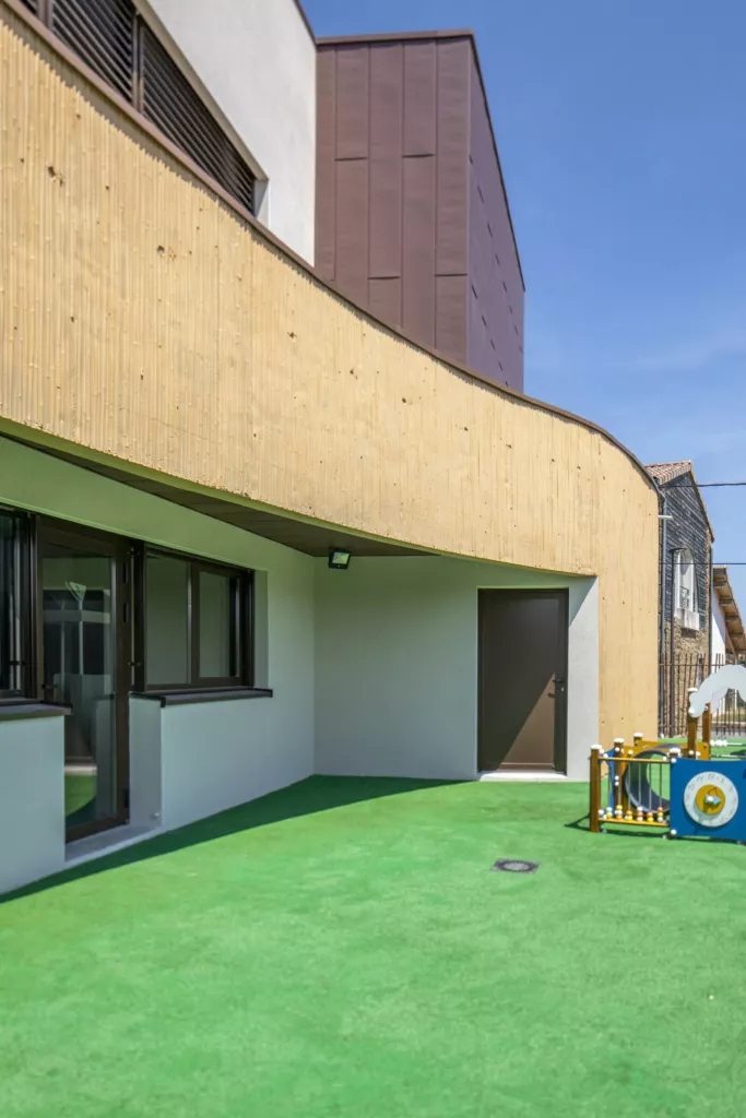 Cour de jeux en gazon synthétique au pied du bâtiment bois – pôle enfance « Jaloine », Saint-Romain-d’Ay (Ardèche), AEA Architecte Constructeur