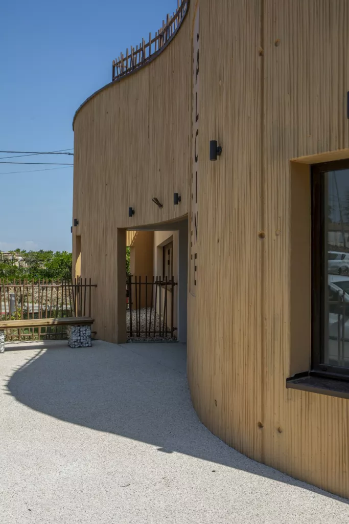 Entrée sous la façade arrondie en bois – pôle enfance « Jaloine », Saint-Romain-d’Ay (Ardèche), AEA Architecte Constructeur