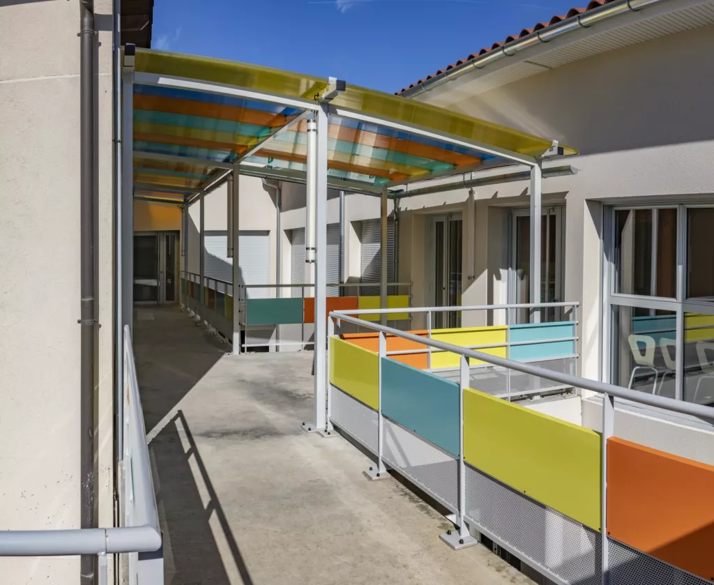 Coursive extérieure aux garde-corps colorés – restaurant scolaire de Grenay (Isère), AEA Architecte Constructeur