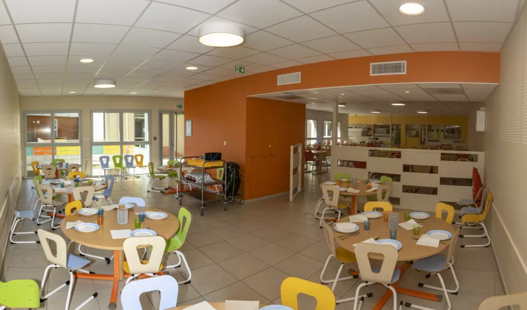 Réfectoire des enfants aux chaises colorées – restaurant scolaire de Grenay (Isère), AEA Architecte Constructeur