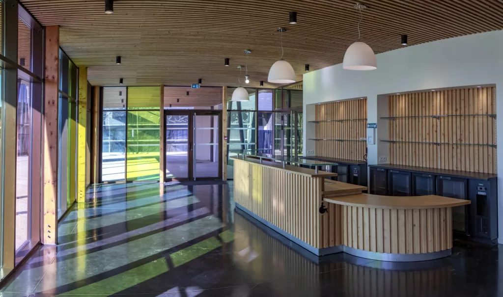 Hall et bar devant des vitrages colorés – salle de réception « L’Espace », Roussillon (Isère), AEA Architecte Constructeur
